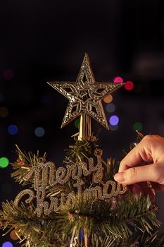 Christmas background concept- beautiful decor bauble hanging on the Christmas tree with sparkling light spot, blurry dark black background, copy space, close up.