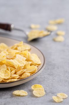 Corn flakes bowl sweeties with milk on gray cement background, close up, fresh and healthy breakbast design concept.