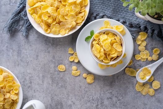 Corn flakes bowl sweets on gray cement background, top view flat lay layout design, fresh and healthy breakfast concept.