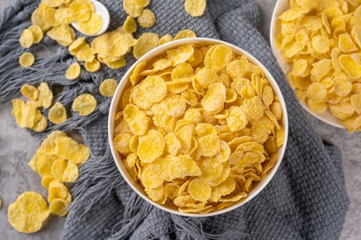 Corn flakes bowl sweets on gray cement background, top view flat lay layout design, fresh and healthy breakfast concept.