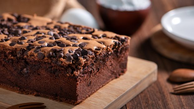 Chocolate flavor Taiwanese traditional sponge cake (Taiwanese castella kasutera) on a wooden tray background table with ingredients, close up.