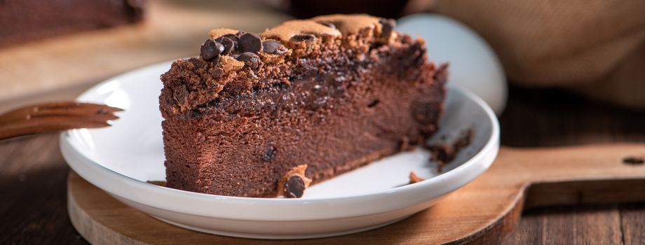 Chocolate flavor Taiwanese traditional sponge cake (Taiwanese castella kasutera) on a wooden tray background table with ingredients, close up.