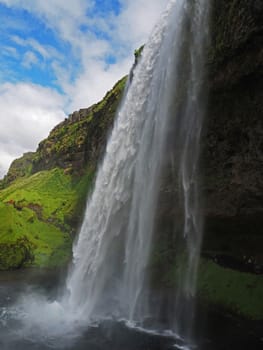 famous icelandic waterfall Seljalandsfoss with a blue sky clouds