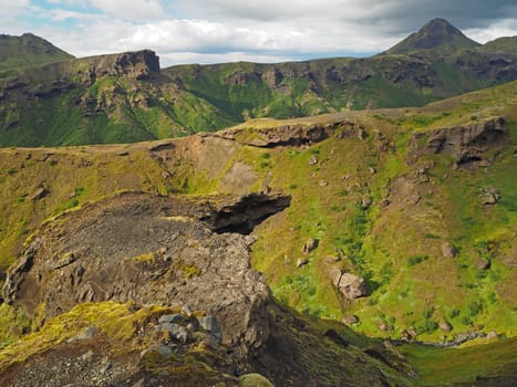 rock formation and eroded mouintains covered grass nad moss in thorsmork national park iceland