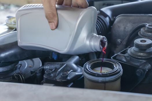 Close up hands of mechanic doing car service and maintenance. hydraulic Oil change new replace