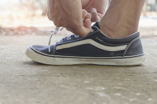 Male athletes tie a shoelace to prepare for exercise by the run. Exercise is a healthy exercise.