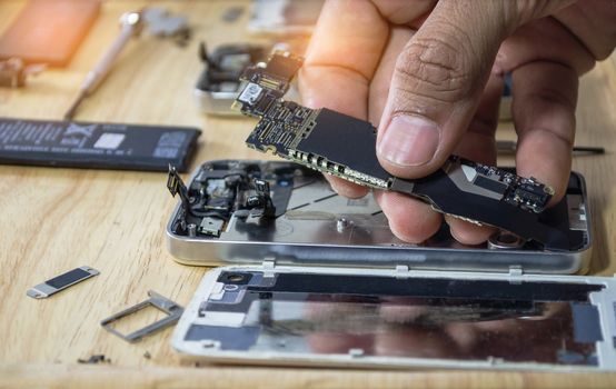 Iphone motherboard repairs into the motherboard for smartphone By professional technician on desk