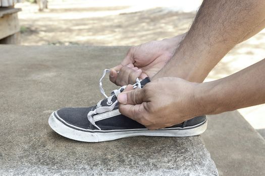 Male athletes tie a shoelace to prepare for exercise by the run. Exercise is a healthy exercise.