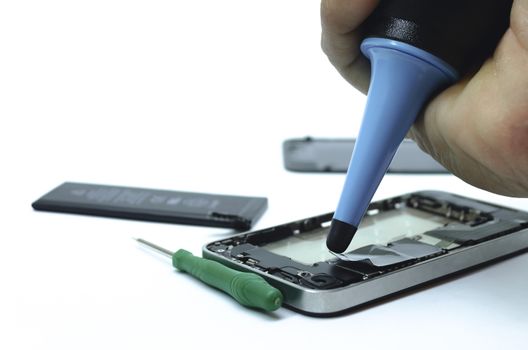 Phone cleaning and repairs into the motherboard for smartphone By professional technician on desk.