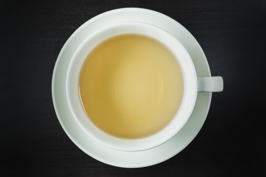 Top view of the tea in a white cup, Place on dark wood flooring