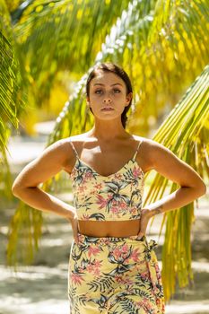 A beautiful brunette model enjoys the soft light under a palm tree in the Yucatán Peninsula near Merida, Mexico