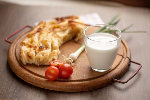 Traditional balkan breakfast - Borek or Burek pie with cheese aranged on wooden table