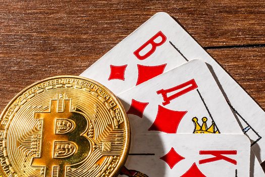 Bitcoin on top of playing cards. Online gambling with cryptocurrency.