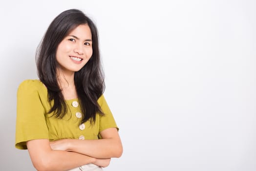 Portrait Asian beautiful young woman standing smile seeing white teeth, She crossed her arms and looking at camera, shoot photo in studio on white background