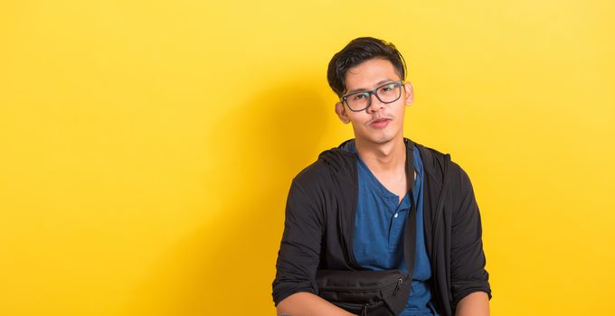 Headshot portrait of Asian young handsome man wear eyeglasses or spectacles, studio short isolated on yellow background with copy space, Fashion male beauty concept