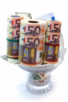 Monetary denominations laid in a vase on a white background