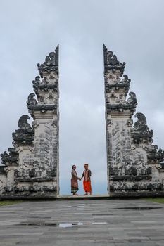 Happy young couple jumping in temple gates of heaven, water reflection. Perfect Honeymoon concept. Lempuyang Luhur temple in Bali, Indonesia. Asia travel concept. Bali, Indonesia.