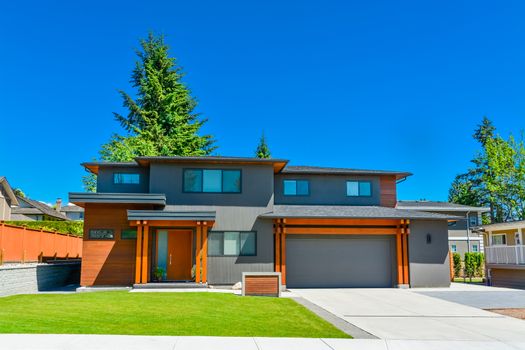 Newly renovated family house in Vancouver, British Columbia. Residential house with wide garage door and concrete driveway