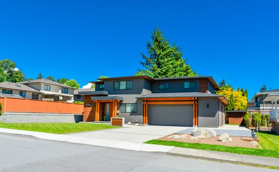 Newly renovated family house in Vancouver, British Columbia. Residential house with wide garage door and concrete driveway