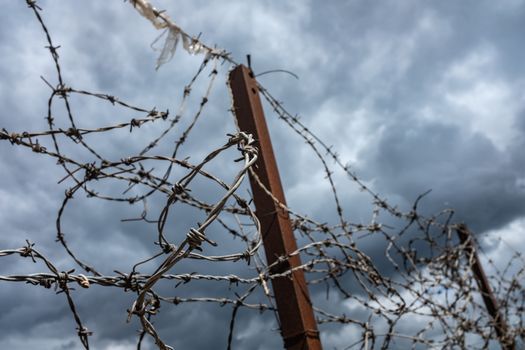 Ugly Old Barbed Wire On A Fence With An Overcast Sky And Copy Space
