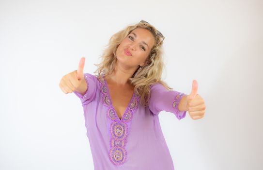 Pretty blonde woman in lilac caftan smiling and doing finger up gesture