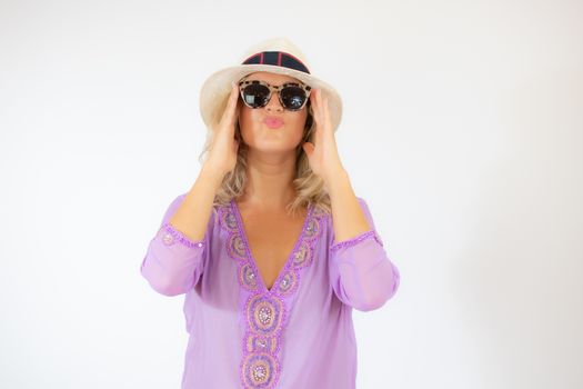 Pretty blonde woman wearing sunglasses and with a lilac caftan