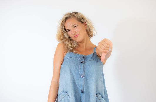 Pretty blonde woman in blue dress making finger down gesture