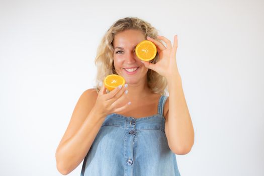 Pretty blonde woman in blue dress smiling with an orange in the eye