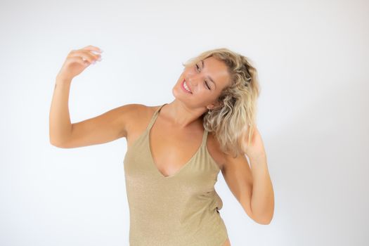 Pretty smiling blonde woman in golden swimsuit