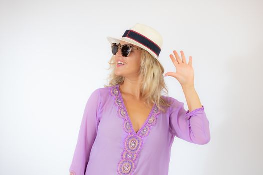 Pretty blonde woman wearing sunglasses and with a lilac caftan