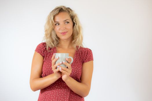 Pretty blonde woman in red dress with a cup of coffee