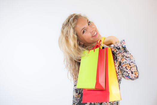 Pretty blonde woman in a flowery dress gesturing on white background