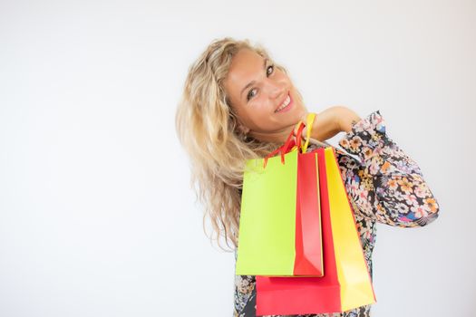 Pretty blonde woman in a flowery dress gesturing on white background