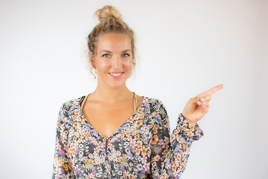 Pretty blonde woman in a flowery dress on white background