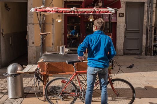 Lyon, France -- November 6, 2017 -- A cyclist stops by a food cart outside a restaurant in Lyon. Editorial Use Only.