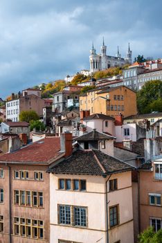 Vertical shot of houses in Lyon leading to the Basilica of Notre-Dame de Fourviere at the top of the city.