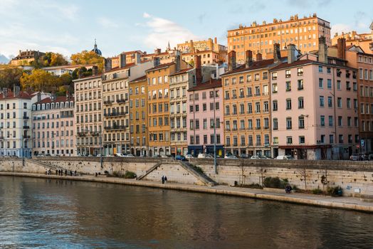 Afternoon landscape scene of apartment buildings along a bank of the Saone River in Lyon, France.