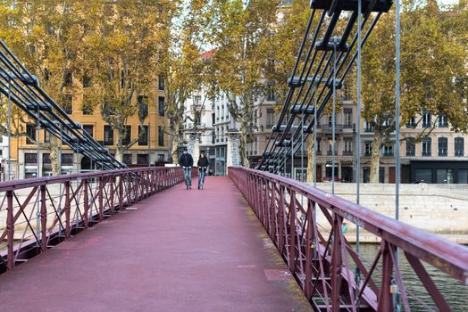 Lyon, France--November 5, 2017--Two cyclists are riding thier bicycles over the Saint Vincent Bridge in Lyon. Editorial Use Only.