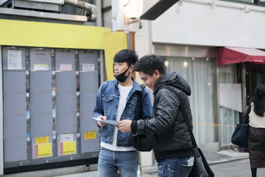 Two young asian handsome man travel in the city and searching the way to visit the best famous place