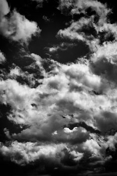 Cloudscape texture background of moody black and white dramatic monochrome cumulus clouds