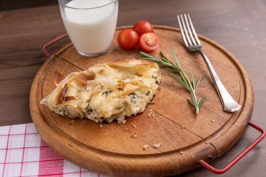 Traditional balkan breakfast - Burek pie with cheese and spinach served on vooden table