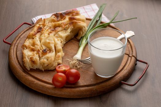 Traditional balkan breakfast - Borek or Burek pie with cheese aranged on wooden table