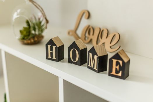 Word home on white wooden background with copy space. Home word concept. Home word written on black wooden houses.