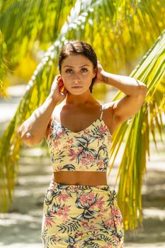 A beautiful brunette model enjoys the soft light under a palm tree in the Yucatán Peninsula near Merida, Mexico