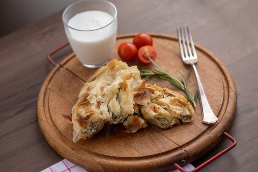 Burek or bourek pie with cheese and spinach served on vooden table