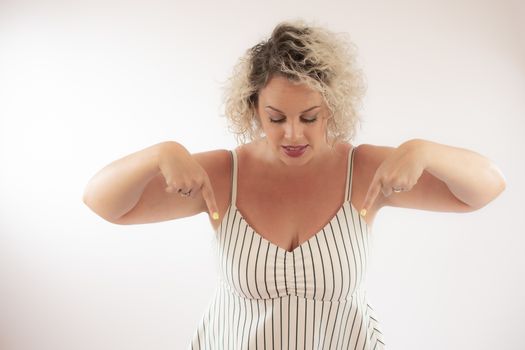 Blonde young woman pointing something with her fingers