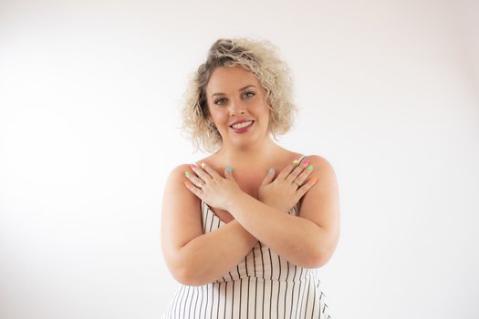 Blonde young woman smiling with her hands crossed