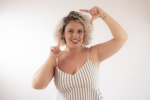 Blonde young woman making portrait gesture