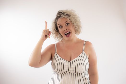 Blonde young woman making pointing with her finger