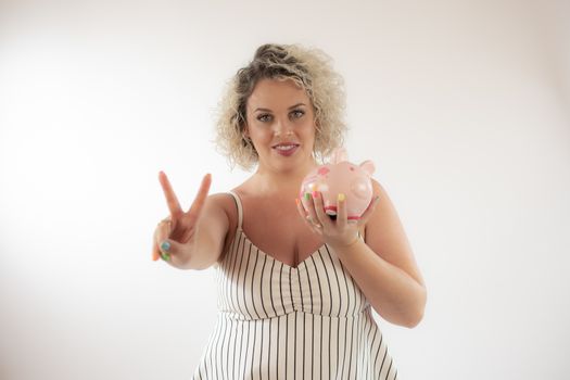 Blonde young woman with a piggy bank